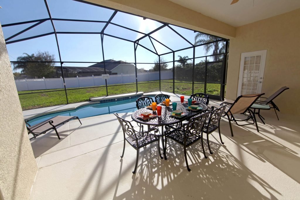patio-dining-area-overlooking-screened-pool-covered-pool-enclosures
